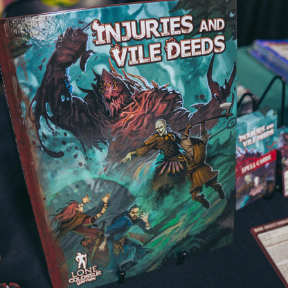 Photo of the hardcover of Injuries and Vile Deeds, a dark fantasy supplement for D&D 5e encouraging tactical, cinematic combat with injury systems, monsters, NPCs, subclasses, spells, magic items, backgrounds, feats, and more